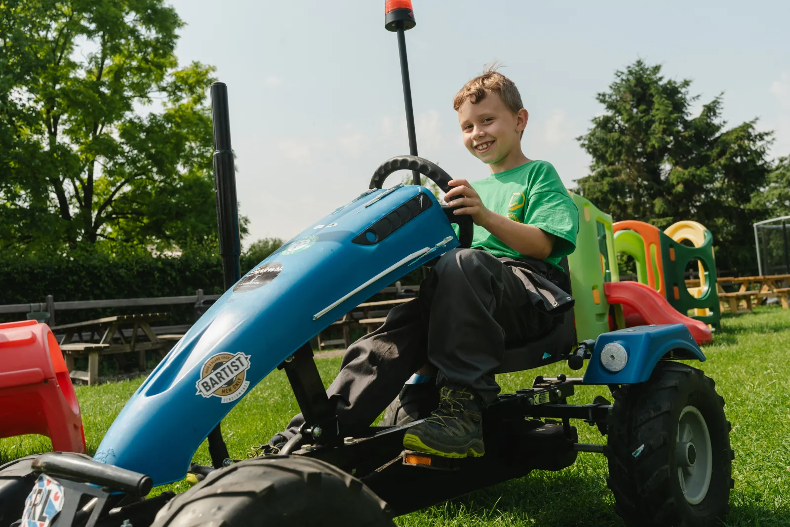 Lachend kind op een BERG gocart in het FarmToys Speel- en Beleefcenter